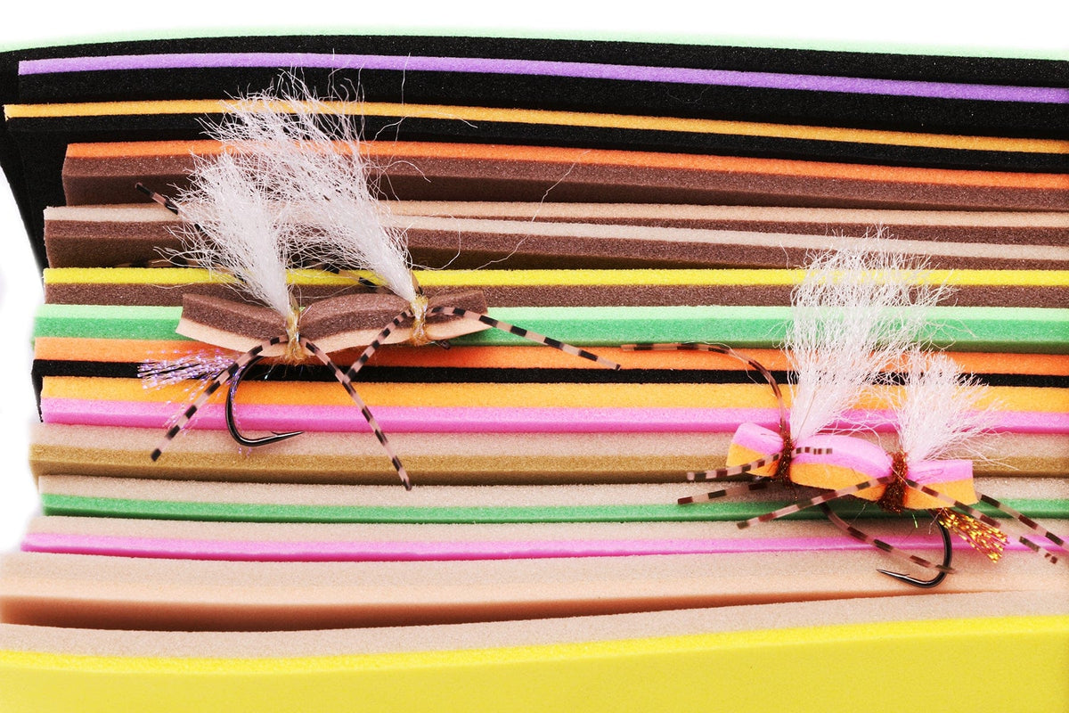 Hareline double-decker foam stacked in neon and earth tones with tied fly-tying foam bugs, white wing posts and visible hooks
