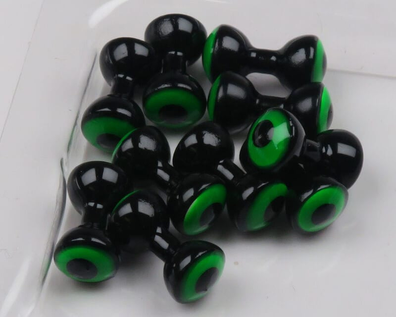 Hareline double-pupil brass fly tying eyes: glossy black dumbbell shapes with bright green inner rings, multiple pieces