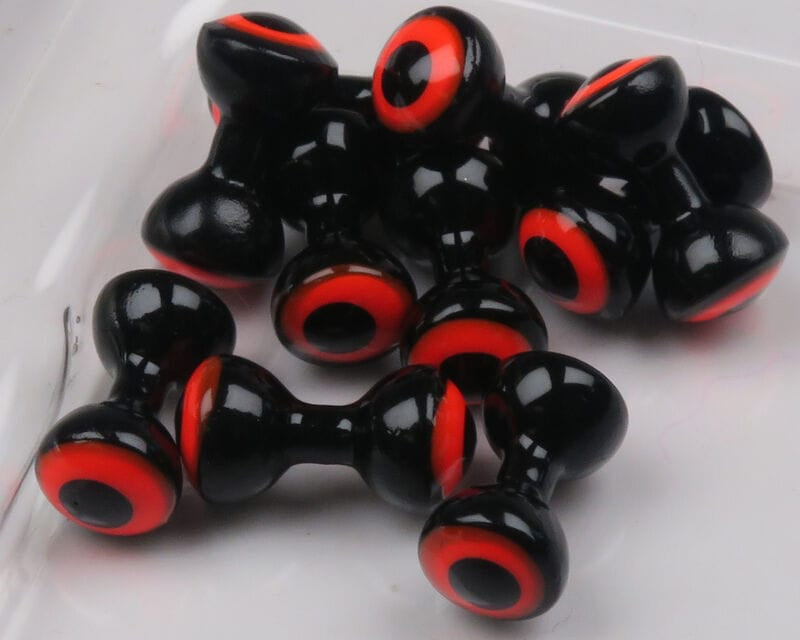 Hareline double-pupil brass fly-tying eyes: glossy black dumbbell-shaped beads with red-orange rings and black pupils