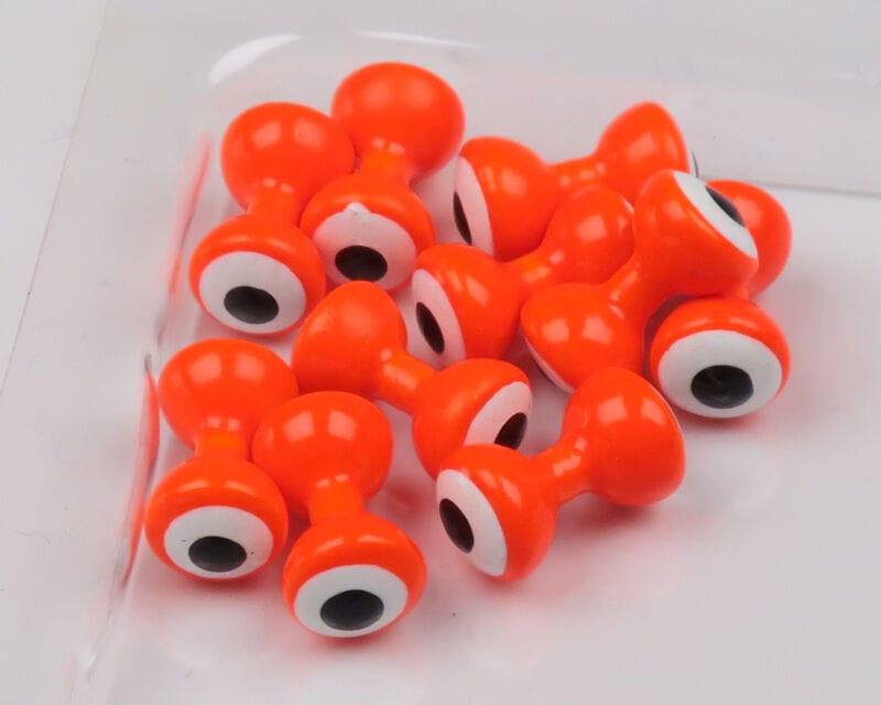 Bright orange double-pupil fly tying eyes with white rings and black centers, glossy hourglass-shaped beads