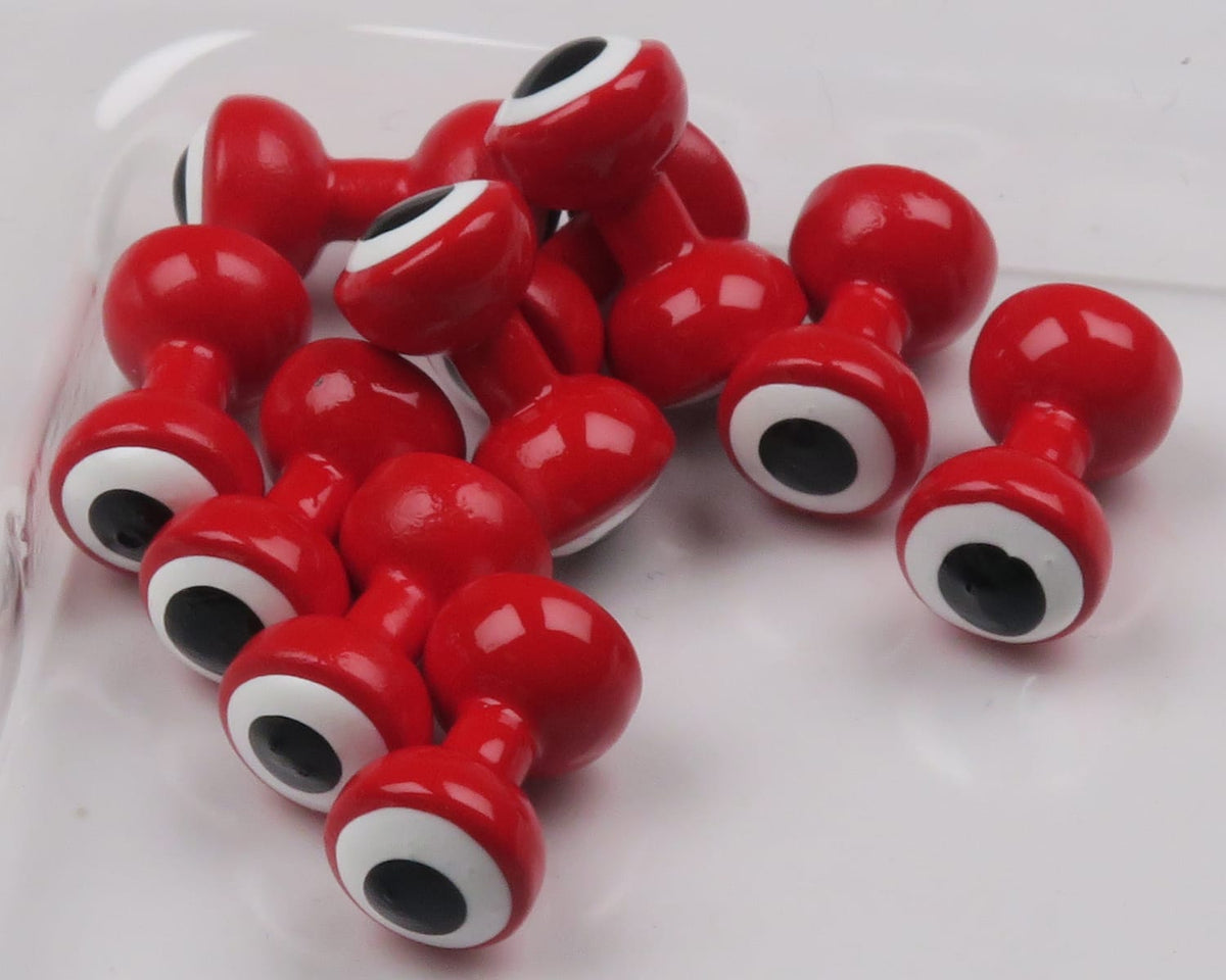 Glossy red double-pupil brass fly-tying eyes with white rings and black centers, stacked cluster, shiny lacquered finish
