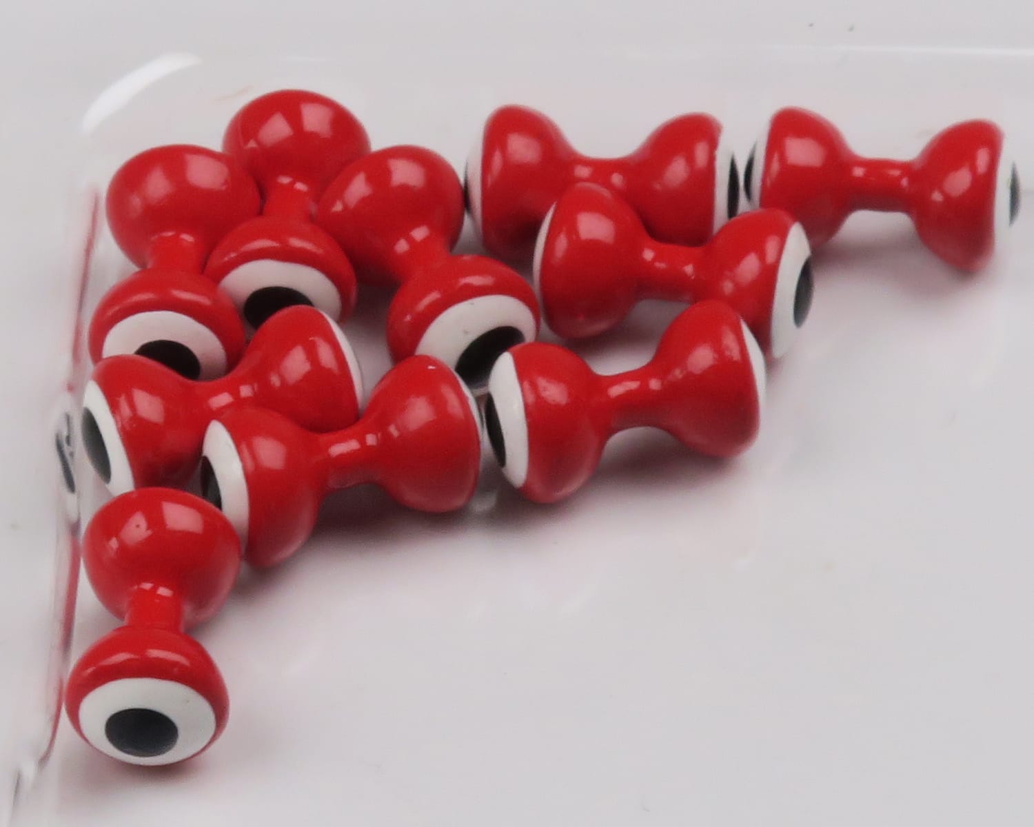 Glossy red double-pupil lead eyes for fly tying, hourglass-shaped beads with white rings and black pupils
