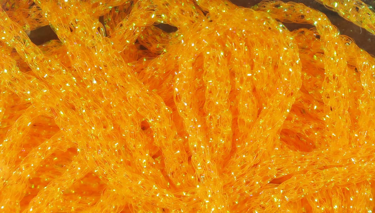 Hareline dyed pearl diamond braid in bright orange, translucent synthetic braid with iridescent flash