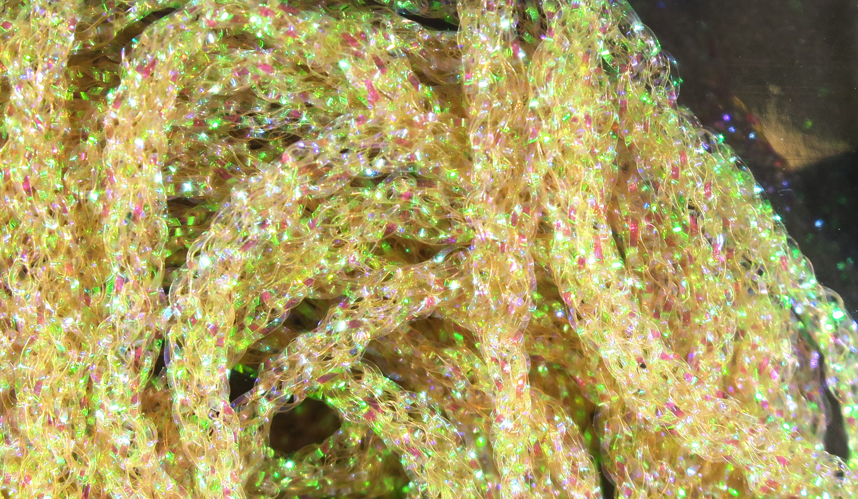 Hareline dyed pearl diamond braid, iridescent yellow-gold synthetic fibers with green and pink sparkle for fly tying