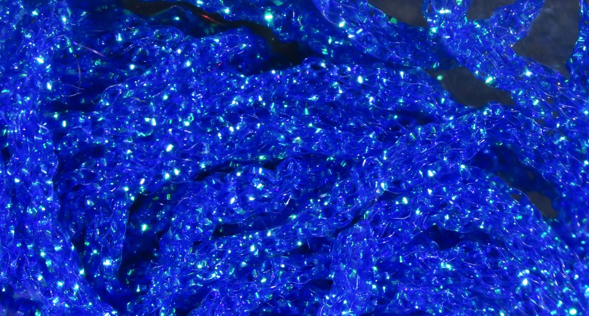 Hareline dyed pearl diamond braid in vibrant electric blue, iridescent synthetic strands for fly tying