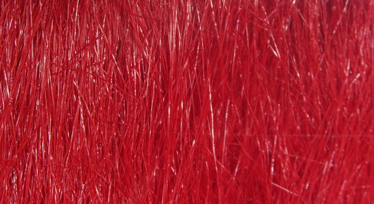 Bright red Hareline craft fur close-up showing glossy, long synthetic fibers for fly tying