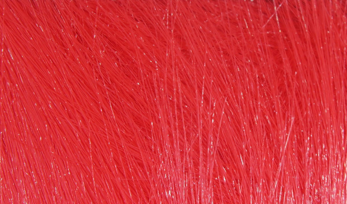 Bright red Hareline Extra Select craft fur with dense, glossy synthetic fibers and long fine strands for fly tying