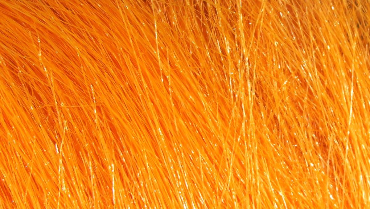 Bright orange Hareline craft fur fibers with glossy synthetic strands for fly tying