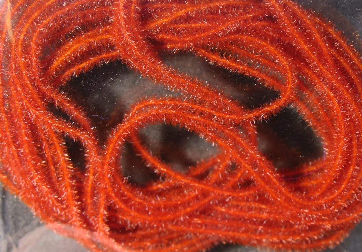 Bright orange Hareline EZ Magic Dub synthetic fuzzy dubbing strands with short sparkle fibers for fly tying