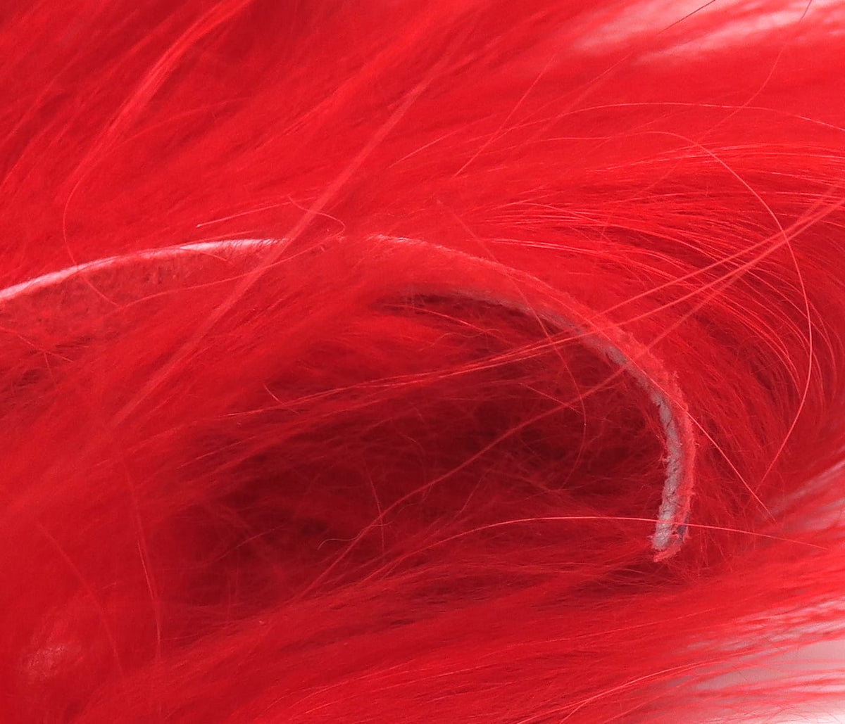 Bright red Hareline Finn raccoon zonker strips with soft long wispy fur for fly tying