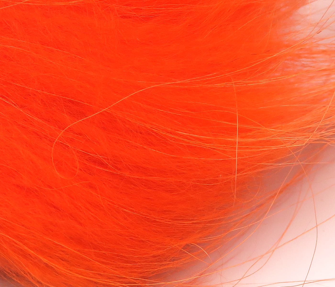 Bright orange Hareline Finn raccoon zonker strips with soft long fur fibers for fly tying