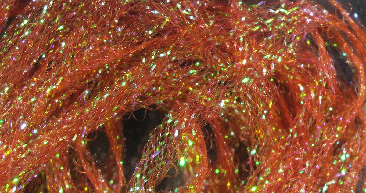 Orange Hareline Flat Diamond Braid sparkly synthetic fibers with green iridescent flash for fly tying