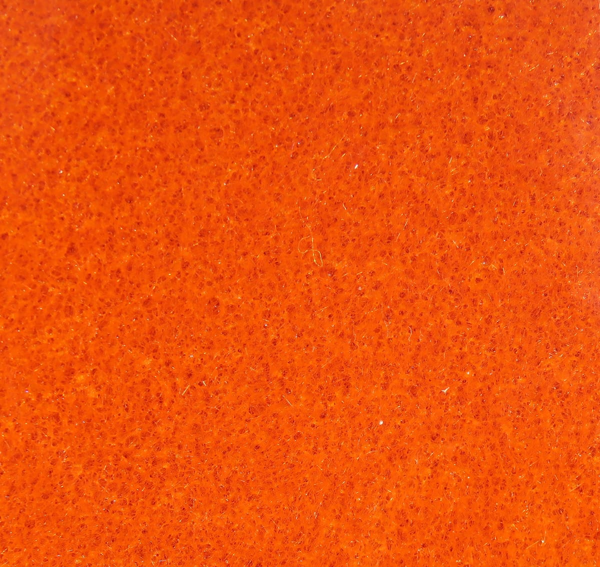Bright orange Hareline furry foam sheet with fine porous texture and short synthetic fibers for fly tying