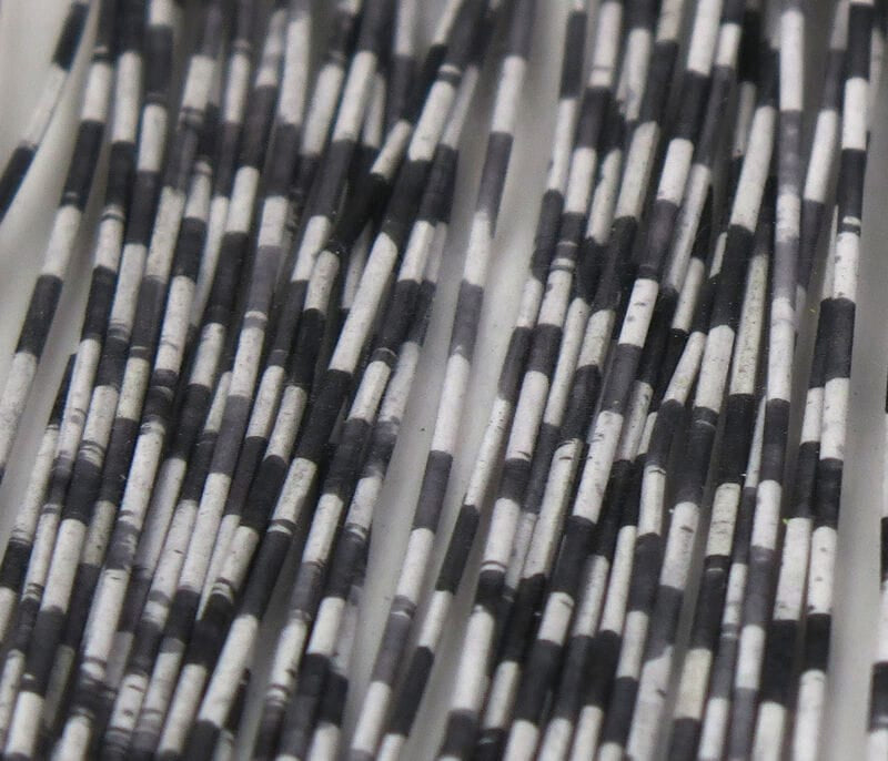 Black and white grizzly barred rubber legs, thin segmented rubber strands for fly tying