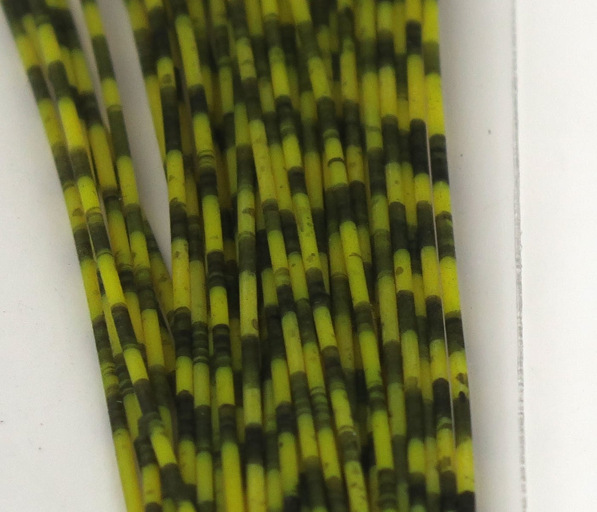Hareline grizzly barred rubber legs, yellow and dark olive green barred rubber strands for fly tying
