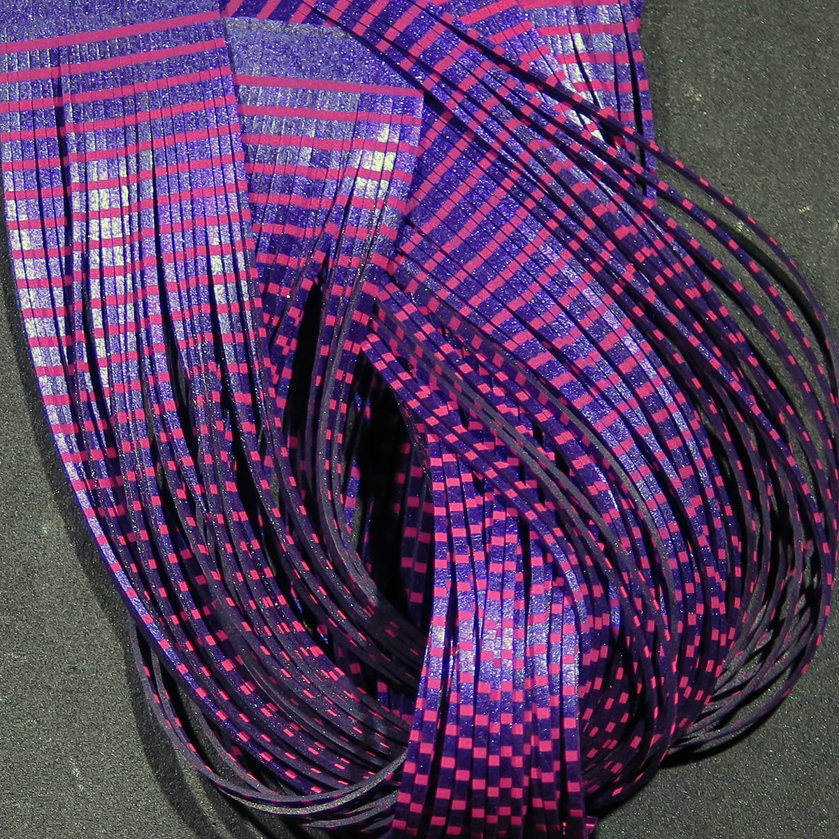 Purple and pink checkered holographic synthetic flutter legs for fly tying, thin flexible strips bundled in loops