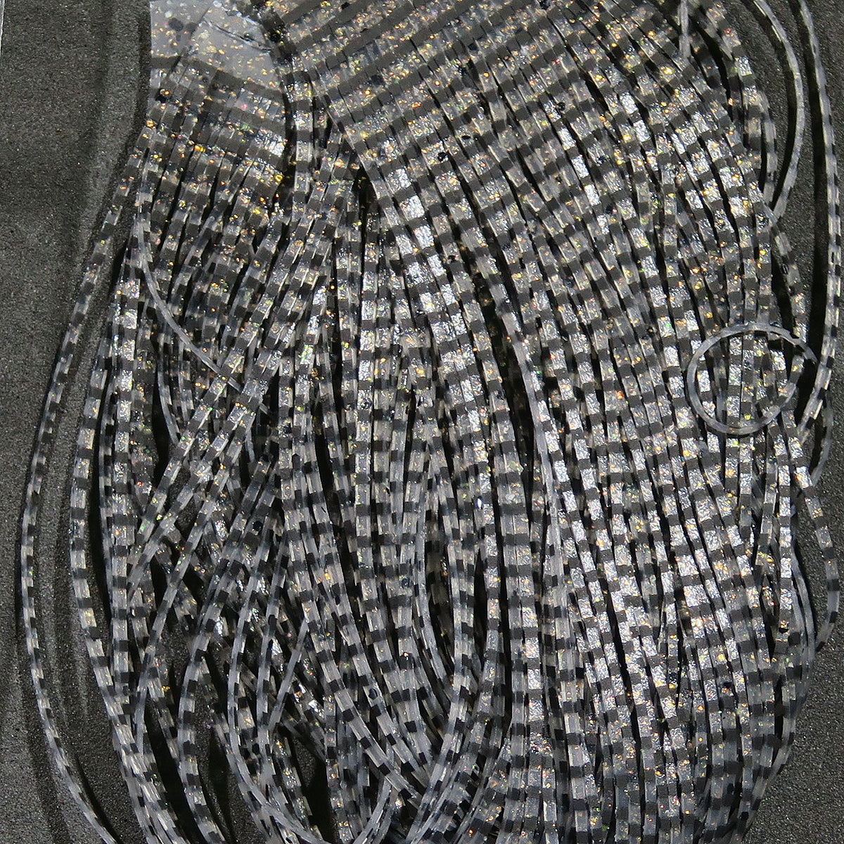 Grizzly gray and black striped synthetic flutter legs with silver holographic specks for fly tying