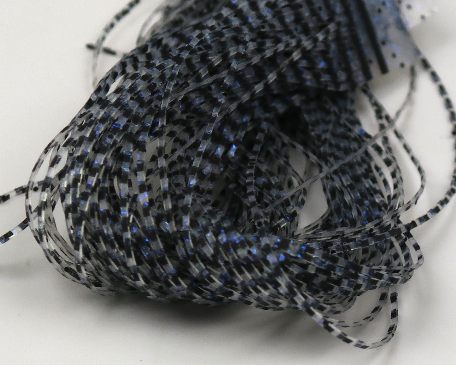 Hareline Grizzly Micro Legs—bundled thin black and gray striped synthetic legs with blue flash for fly tying.