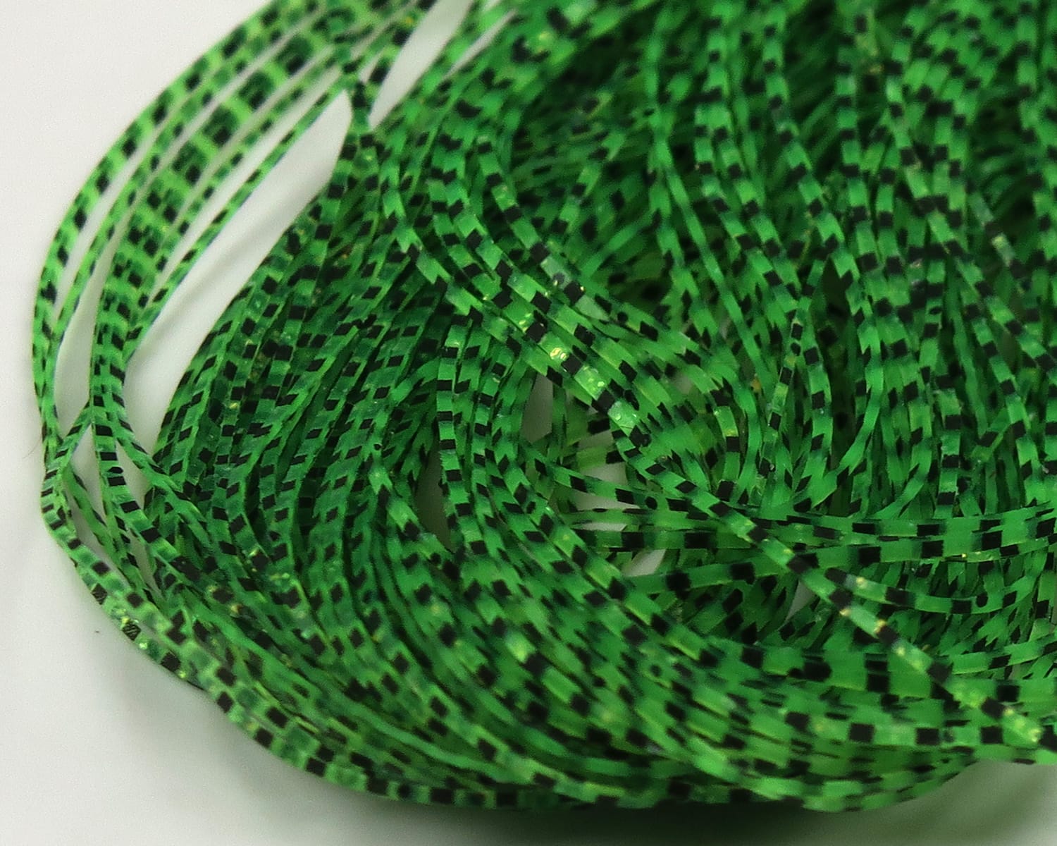 Green grizzly patterned micro legs strips with black barred markings, glossy synthetic fly tying material