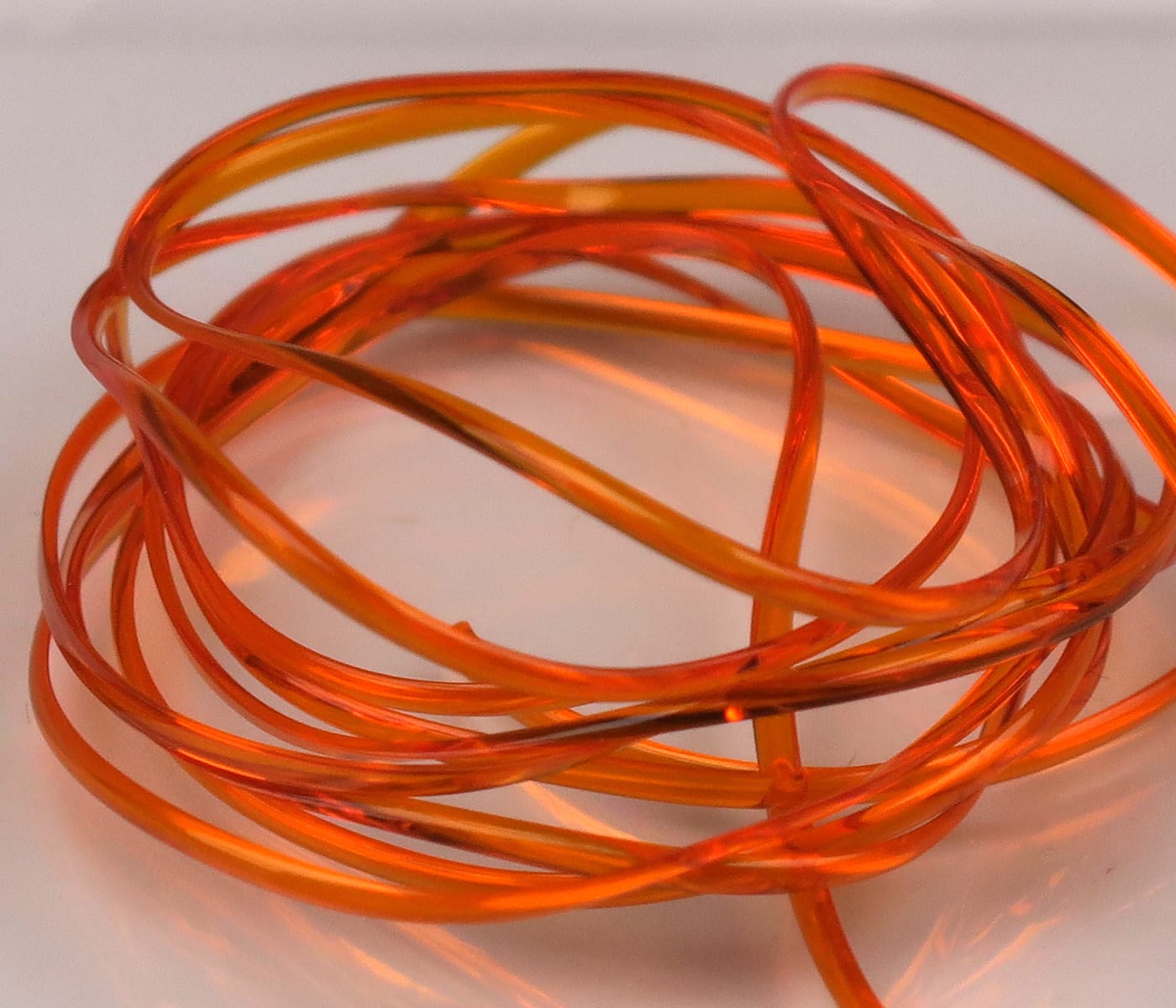 Hareline translucent orange half-round D-rib coiled glossy plastic rib for fly tying