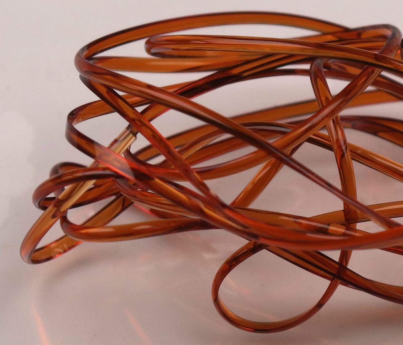 Translucent amber brown half-round D-rib coil made of flexible plastic for fly tying