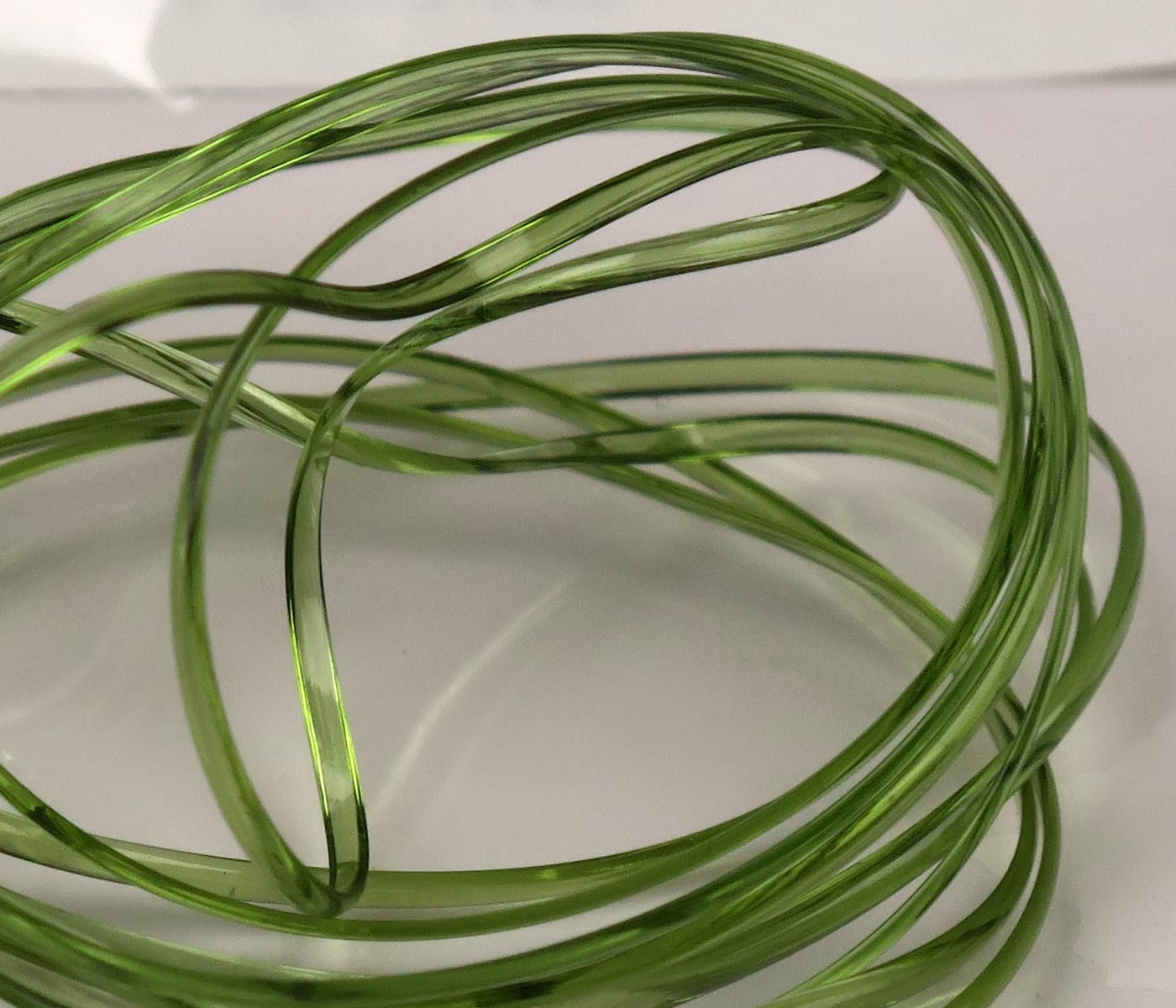 Translucent olive green Hareline half-round D-rib coiled strands, glossy plastic rib for fly tying