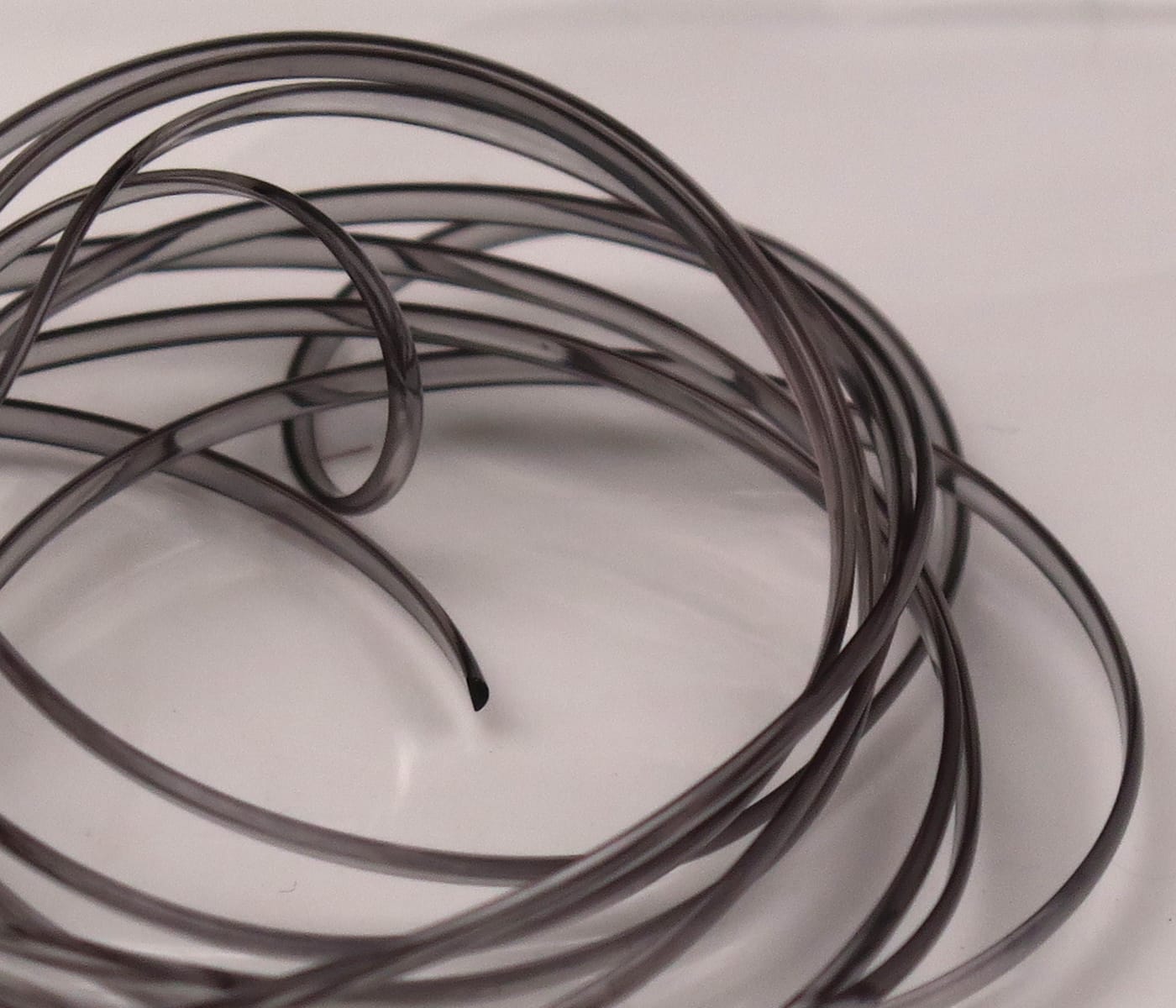 Smoky gray translucent half-round D-rib coils, flexible plastic fly tying rib material for streamers and nymphs