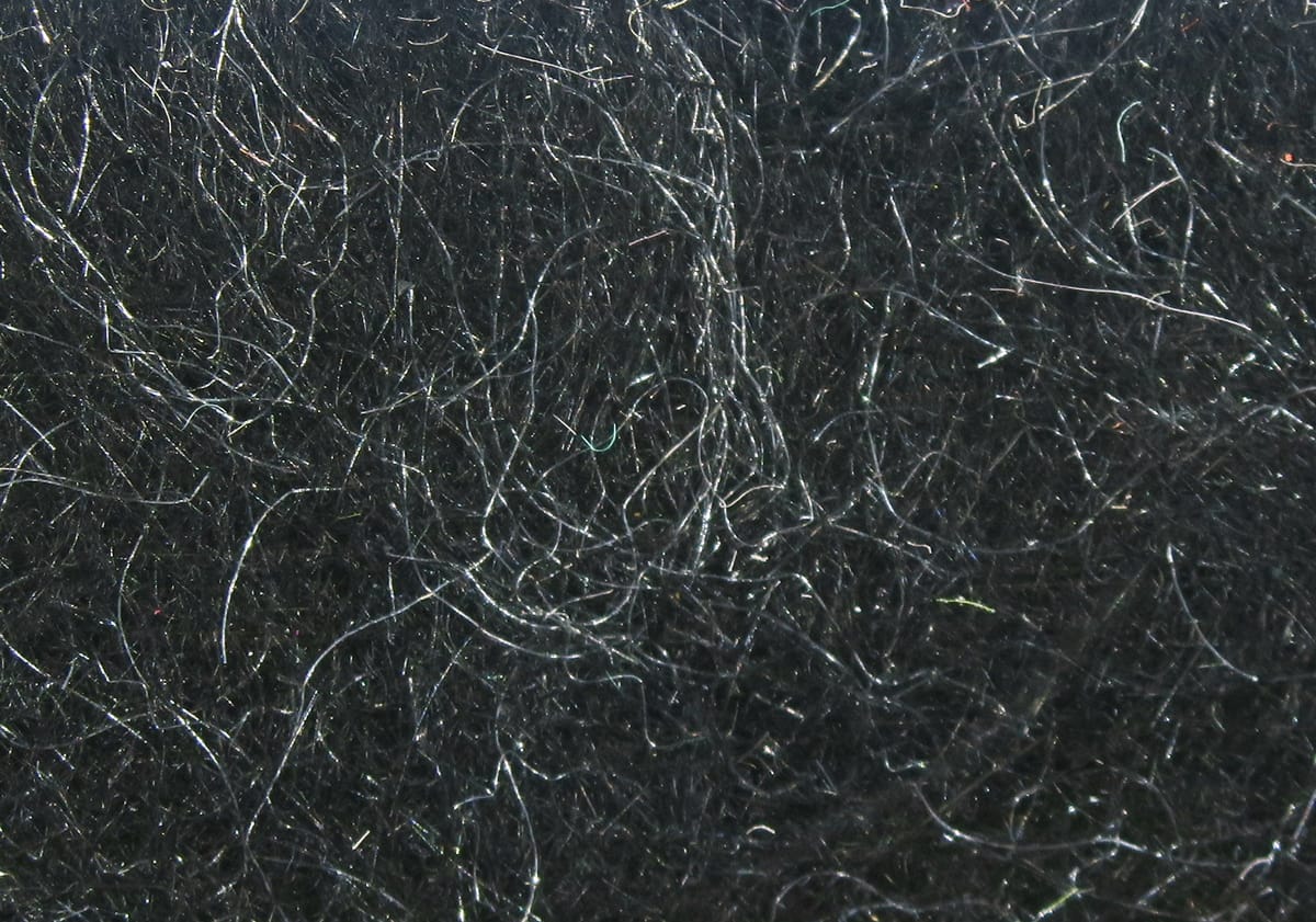 Black synthetic Hare-Tron dubbing with fine shiny iridescent fibers, fluffy tangled fly tying material