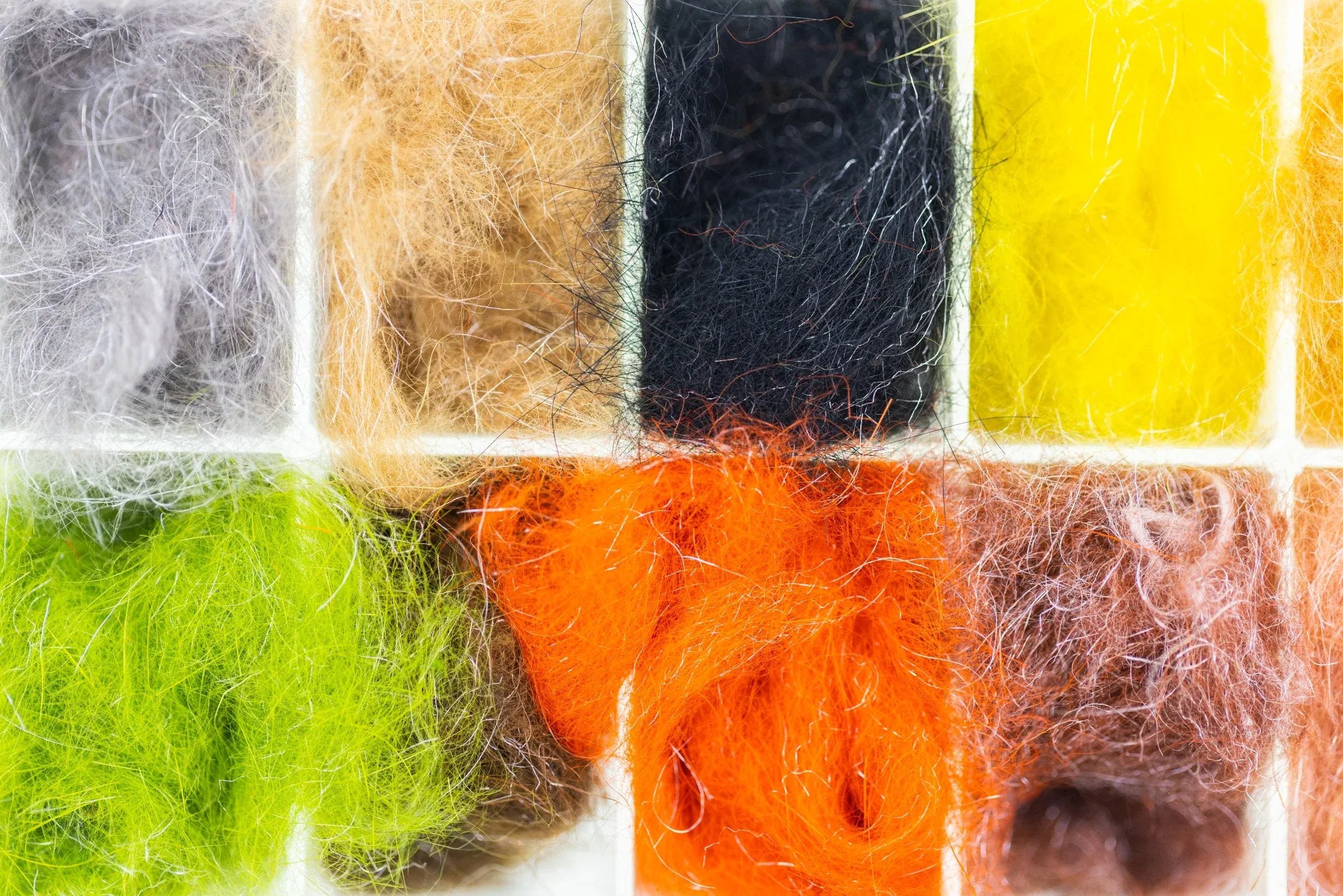 Hareline Hare-Tron multicolor dubbing in tray fluffy synthetic fibers in gray, tan, black, yellow, orange for fly tying