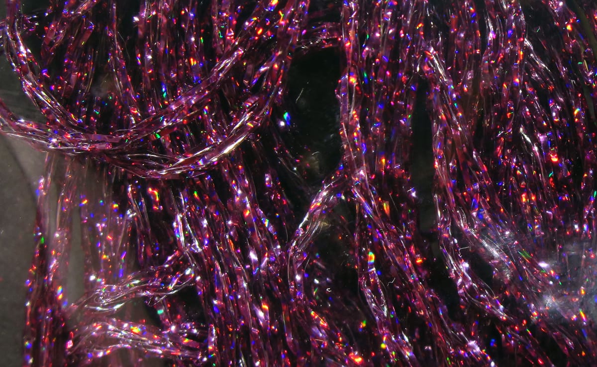 Magenta purple Hareline holographic braid tinsel with rainbow flashes, braided strands for fly tying