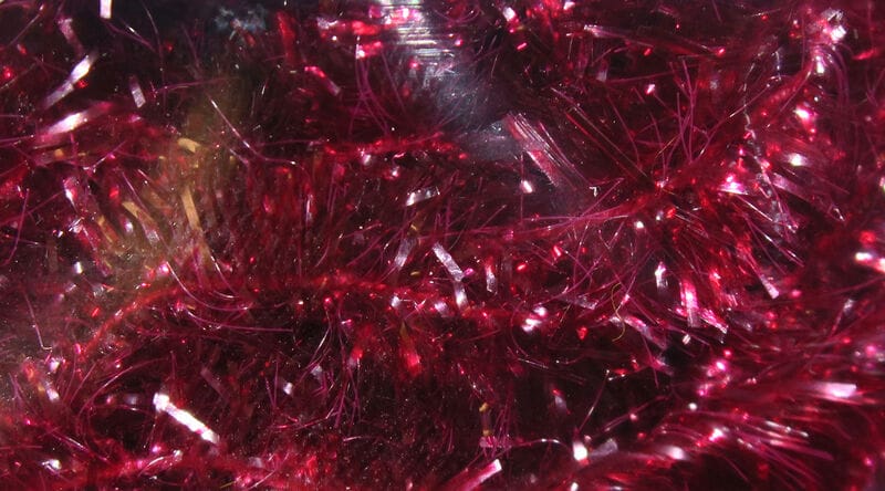 Deep red Hareline Ice Chenille with sparkling metallic fibers and fuzzy tinsel strands for fly tying