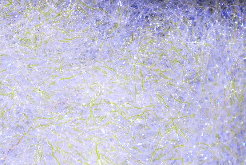 Hareline Ice Dubbing white synthetic fibers with lime-green strands and iridescent glitter sparkle for fly tying