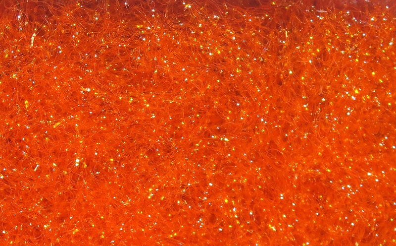 Hareline Ice Dubbing bright orange synthetic fibers with fine iridescent sparkle, fluffy texture for fly tying