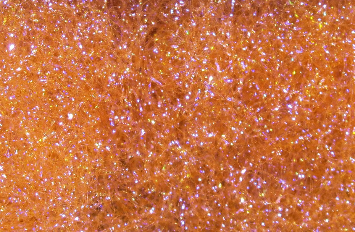 Orange Hareline Ice Dubbing close-up of fine synthetic fibers with iridescent sparkle for fly tying