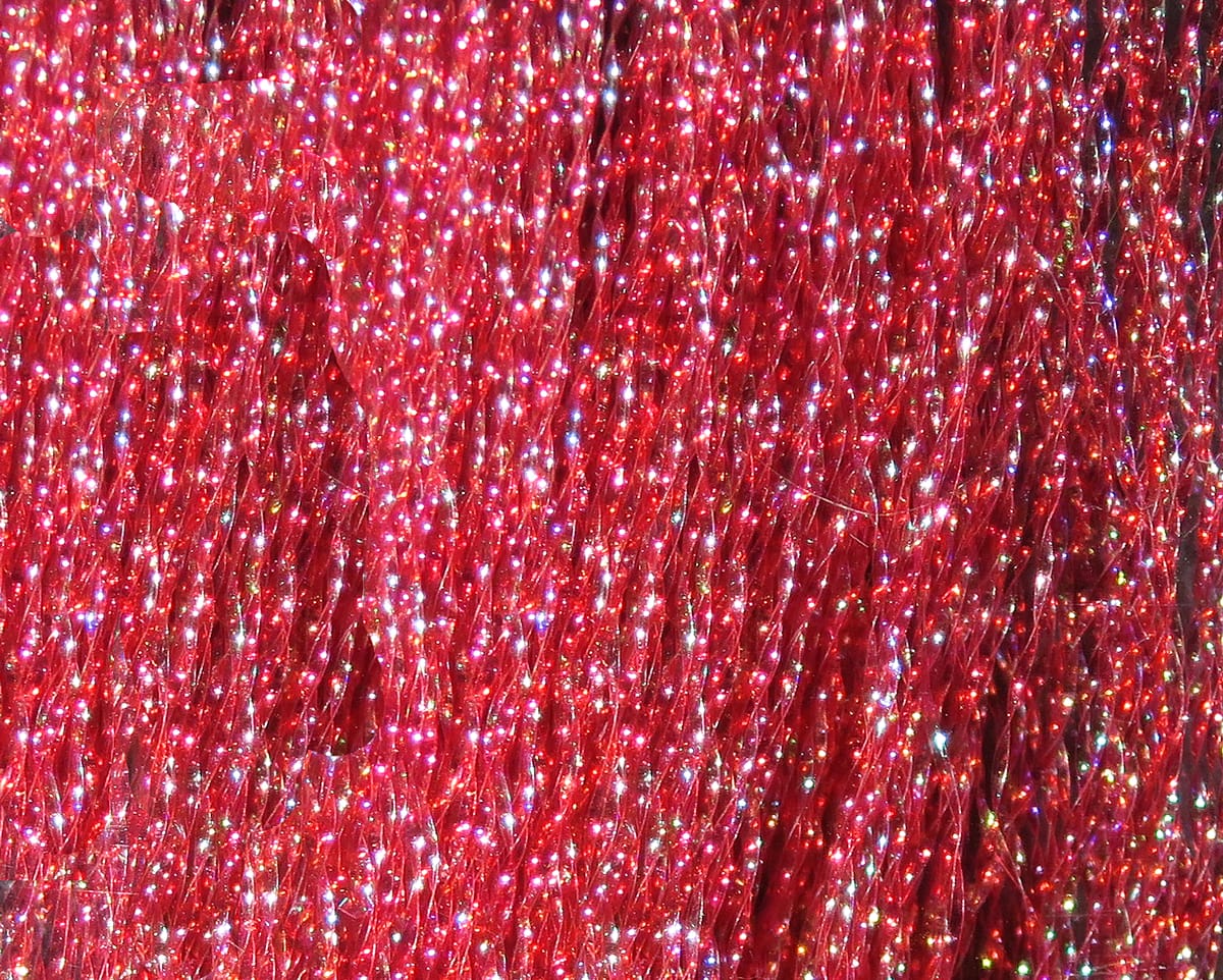 Hareline Krystal Flash fly tying material — red iridescent synthetic strands with holographic sparkle and shimmering flash