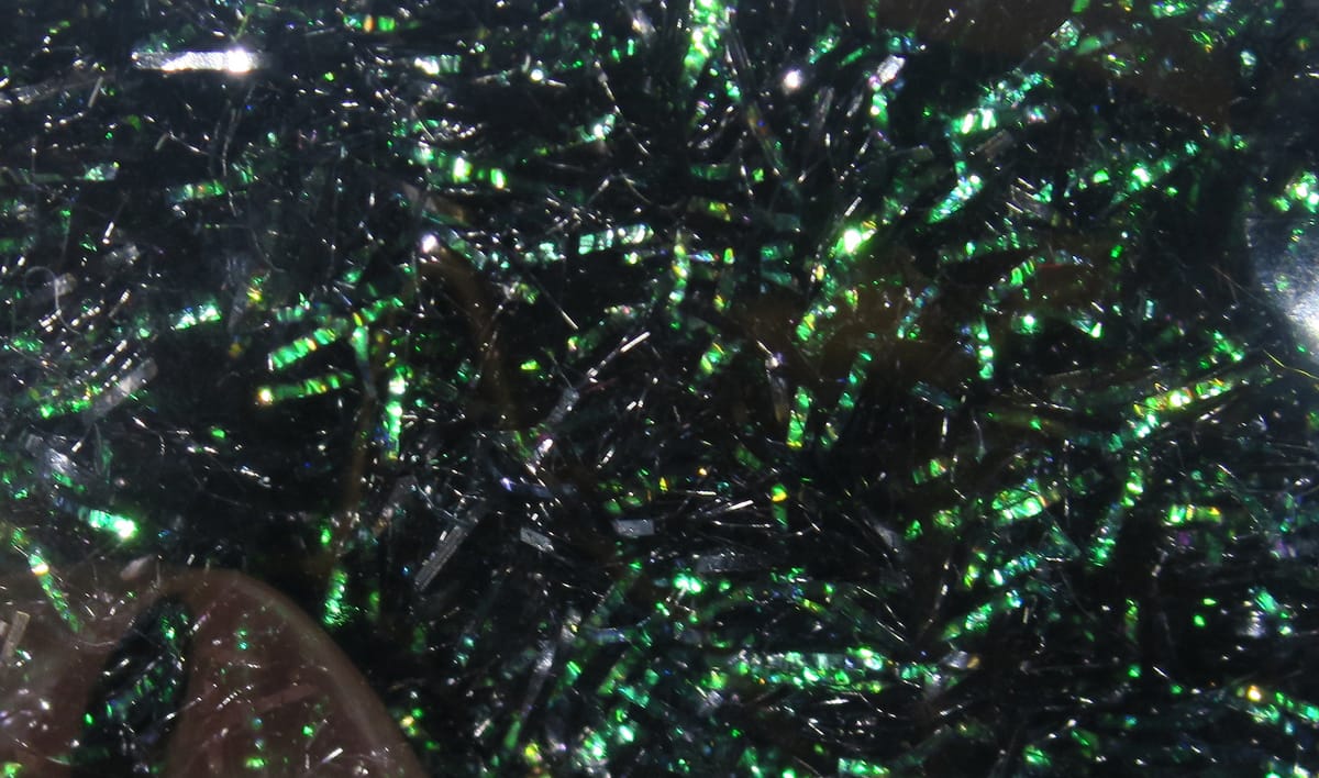 Hareline Krystal Flash chenille strands in black with green iridescent sparkle for fly tying