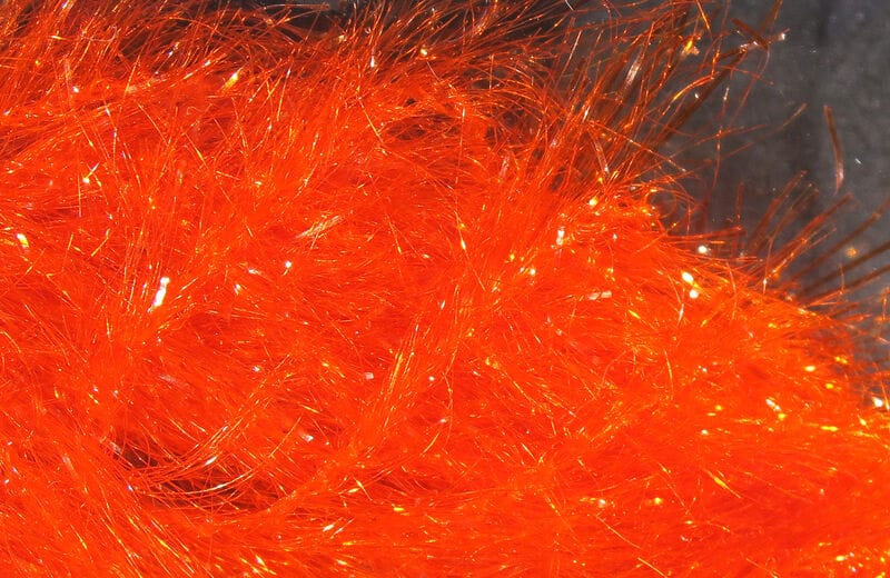 Bright orange Hareline Krystal Hackle synthetic fibers with iridescent tinsel sparkle for fly tying