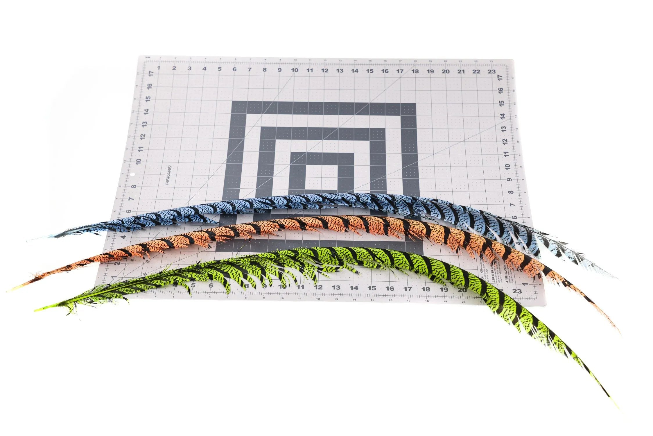 Long Lady Amherst pheasant tail feathers in blue, orange and chartreuse with black barring on grid cutting mat for fly tying