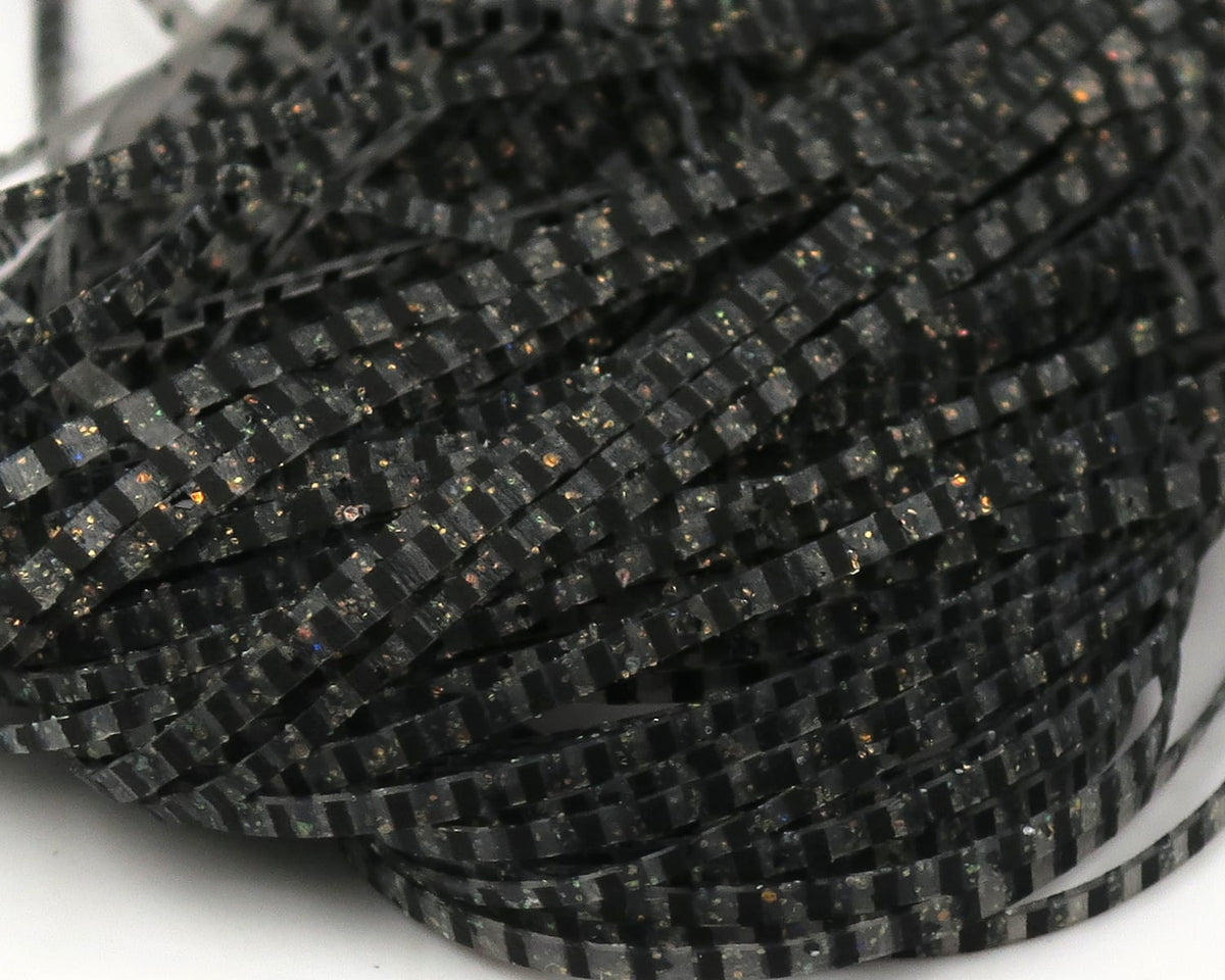 Hareline Magnum predator legs black segmented rubber strands with holographic gold and green flecks for fly tying