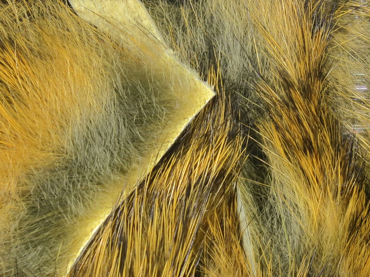 Hareline Magnum rabbit fur strips: golden-brown and olive dense underfur with long glossy guard hairs for fly tying