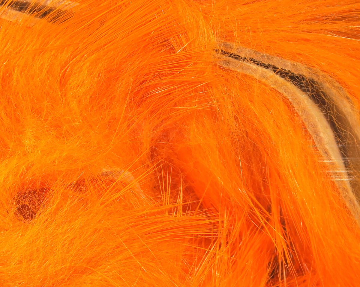 Bright fluorescent orange Hareline Magnum rabbit fur strips, long silky fibers with leather backing for fly tying