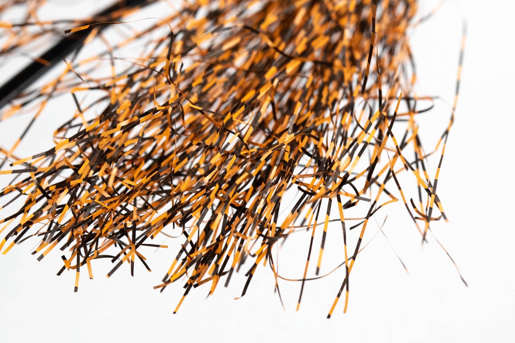 Micro black-barred orange Voodoo fibers, thin glossy synthetic strands with alternating black and orange bars for fly tying.