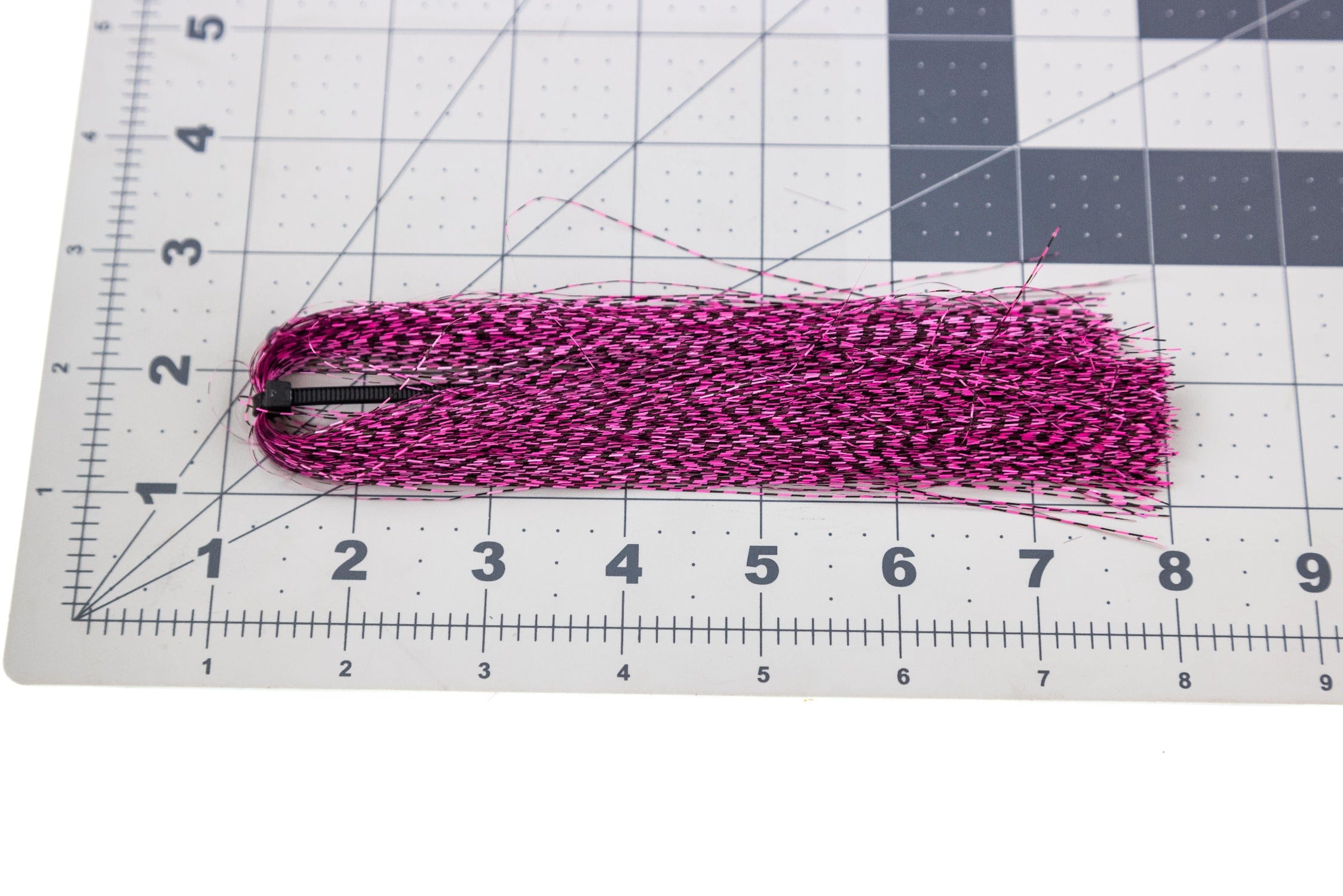 Hot pink and black micro barred synthetic fibers bundle for fly tying, narrow barred Voodoo style on measurement mat