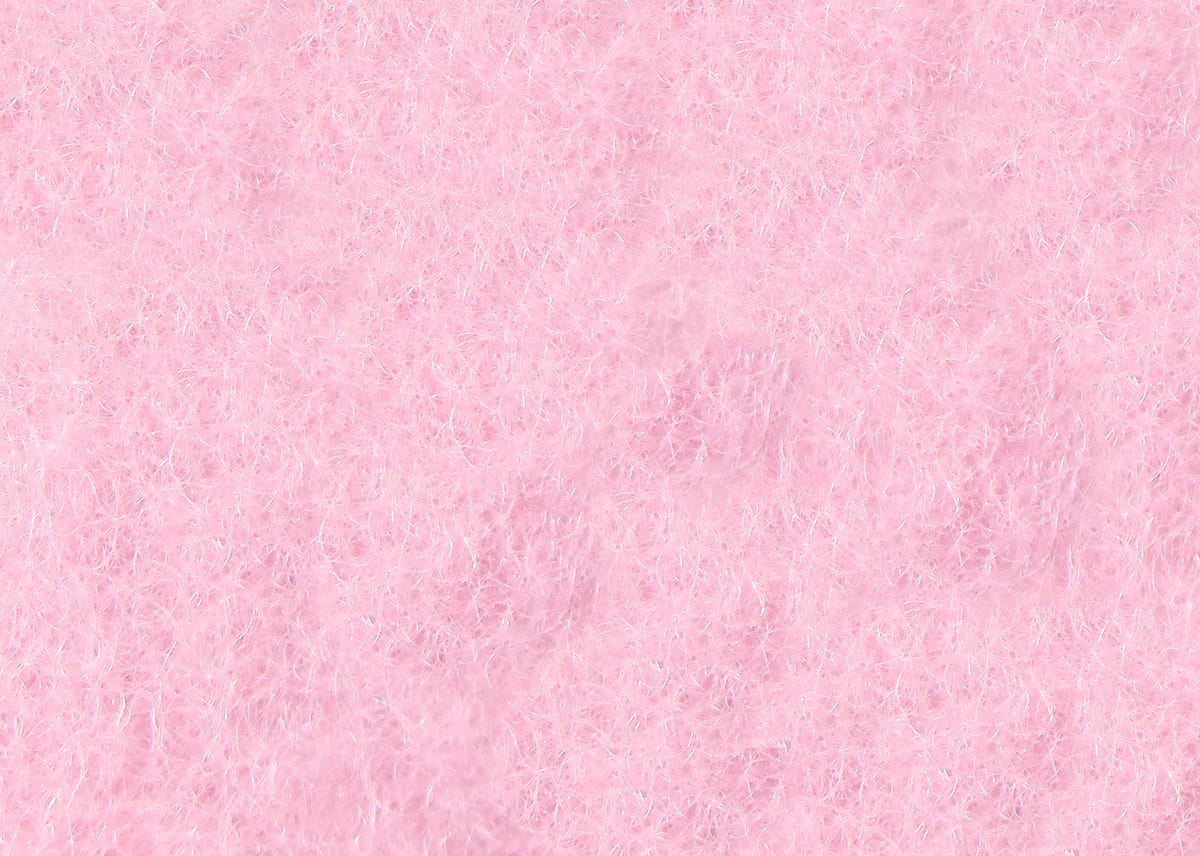 Pink micro dry fly dubbing close-up showing fine synthetic fibers with subtle sparkle, soft fluffy texture for fly tying