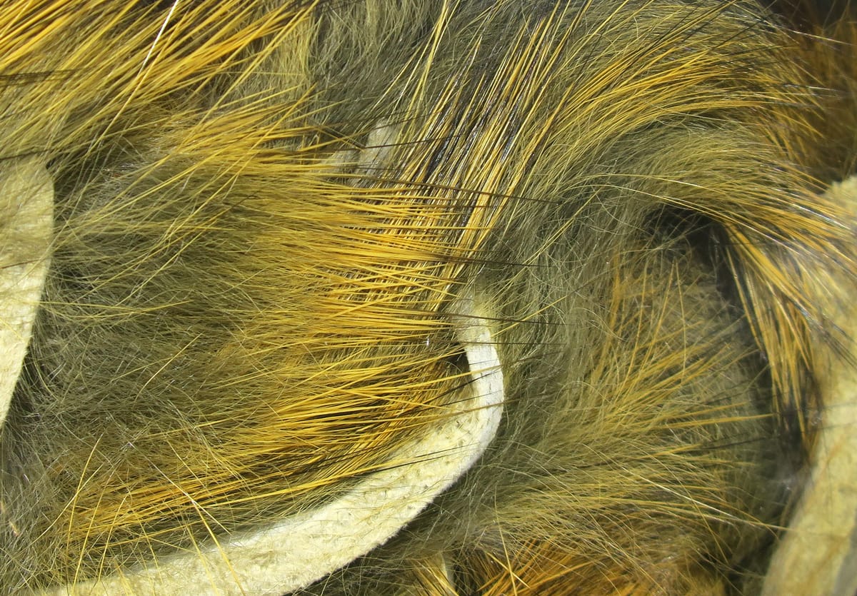 Hareline micro rabbit fur strips in olive brown with golden yellow tips, dense soft fur on fabric backing for fly tying