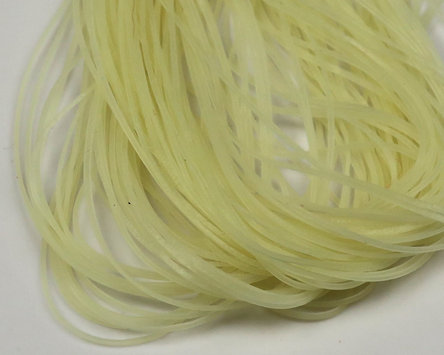 Pale chartreuse translucent micro silicone legs, thin flat strips bundled for fly tying