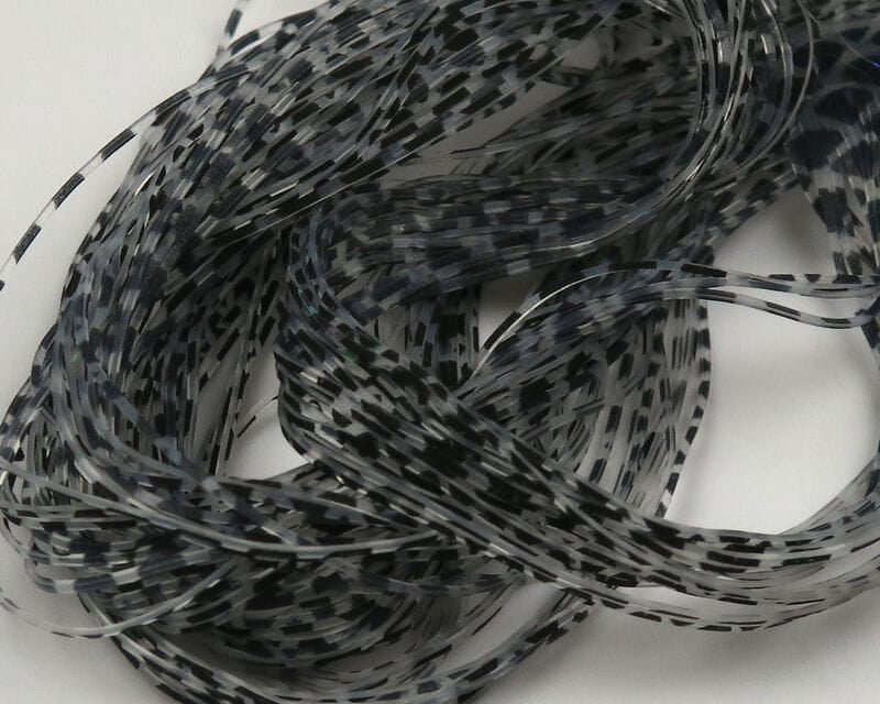 Hareline micro silicone legs, translucent gray thin strips with black speckled pattern, coiled for fly tying