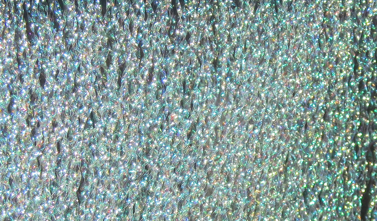 Silver iridescent Hareline flash fibers, fine holographic tinsel strands with green-blue rainbow sparkle for fly tying