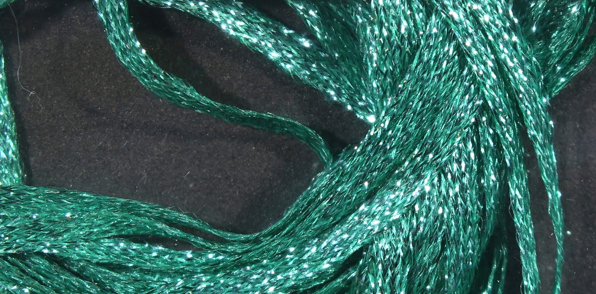 Emerald green Hareline Mini Flat Fly Braid, close-up of sparkly flat braided synthetic strands for fly tying