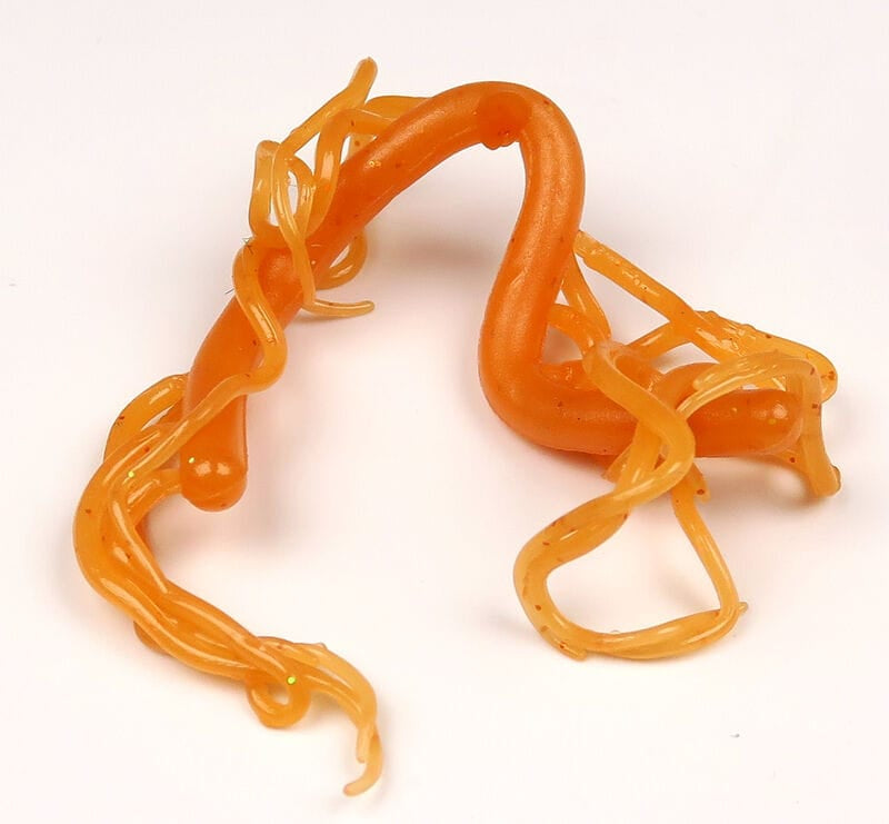 Orange Hareline mini squiggle worms soft plastic lures with thin curly tentacles and subtle glitter for fly tying